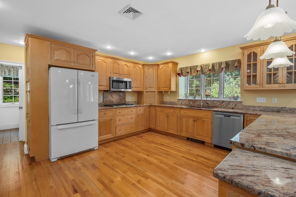 6 Match Point Dennis, MA 02638 - Photo 9 of 42 a kitchen with stainless steel appliances granite countertop a refrigerator a sink dishwasher a stove with large countertops and wooden floor