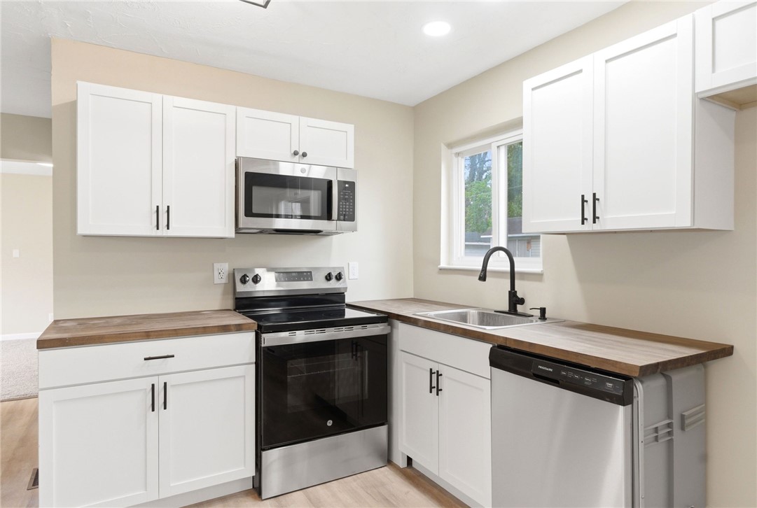 40 Woods Road Springboro, OH 45066 - Photo 26 of 57 This modern kitchen features crisp white cabinetry and essential appliances for daily living.