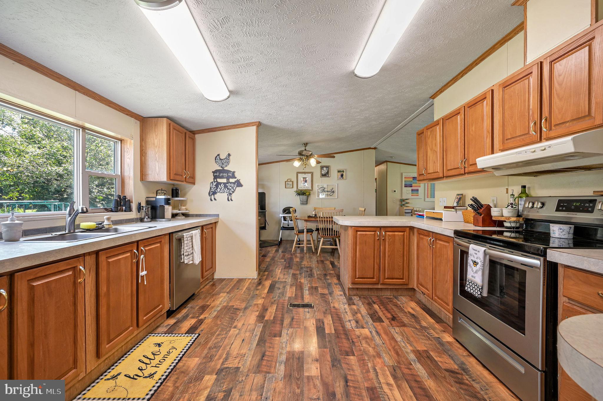 440 Indian Runner Road Felton, DE 19943 - Photo 21 of 50 a kitchen with stainless steel appliances wooden floors stove and wooden cabinets