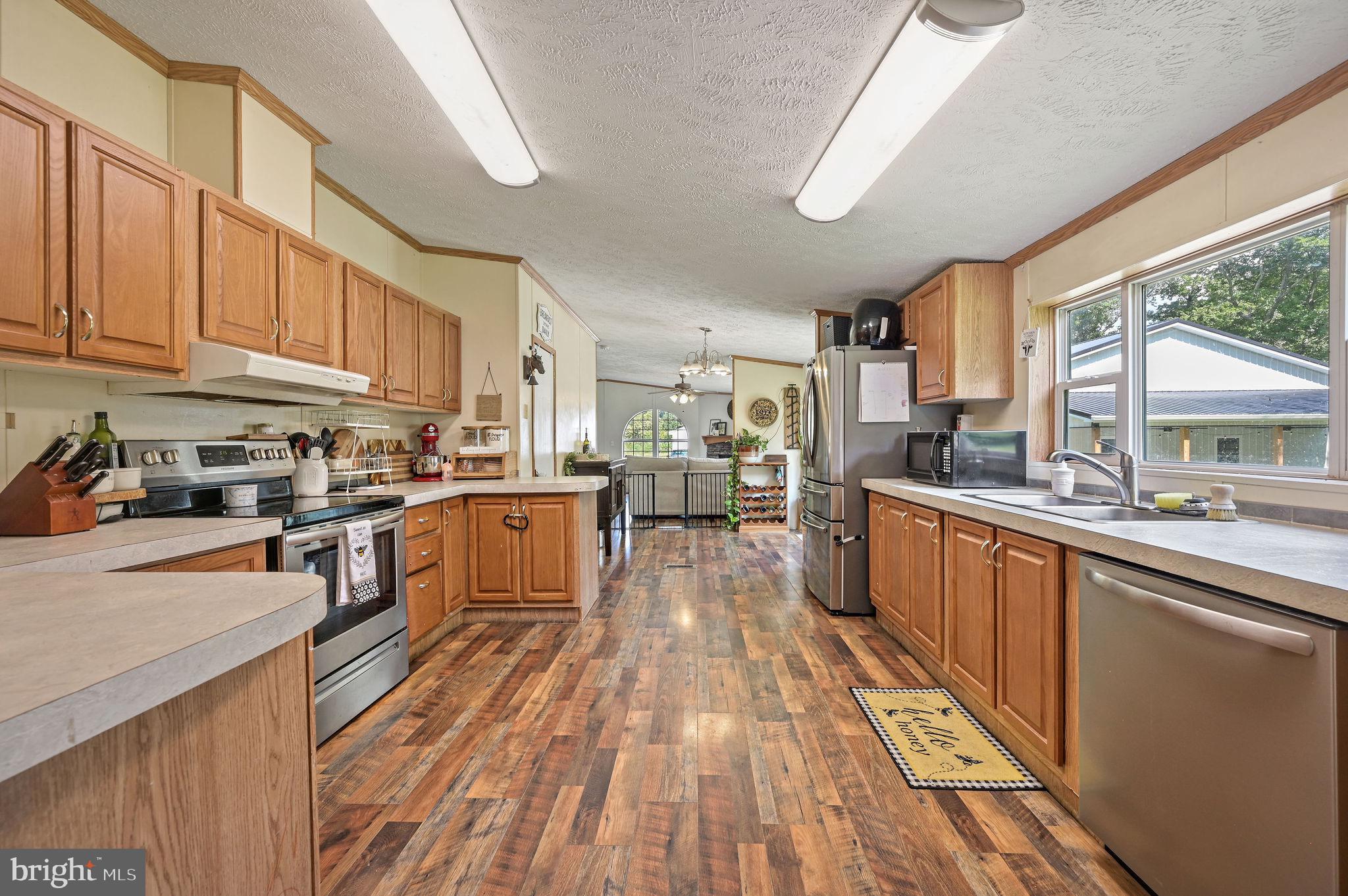 440 Indian Runner Road Felton, DE 19943 - Photo 23 of 50 a kitchen with stainless steel appliances granite countertop lots of counter top space and wooden floors
