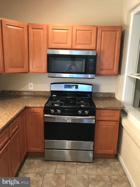 2011 Stenton Avenue, Unit A Philadelphia, PA 19138 - Photo 8 of 20 a kitchen with granite countertop a stove and a microwave