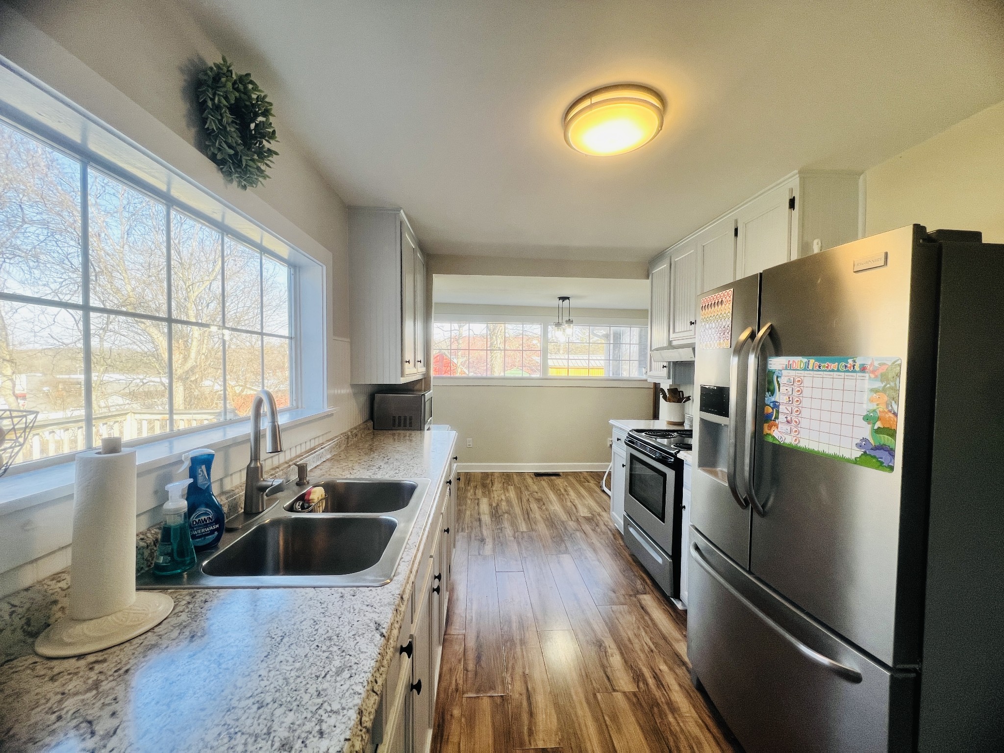 100 Locust Street Alexandria, TN 37012 - Photo 17 of 21 a kitchen with stainless steel appliances granite countertop a sink a refrigerator and wooden floor