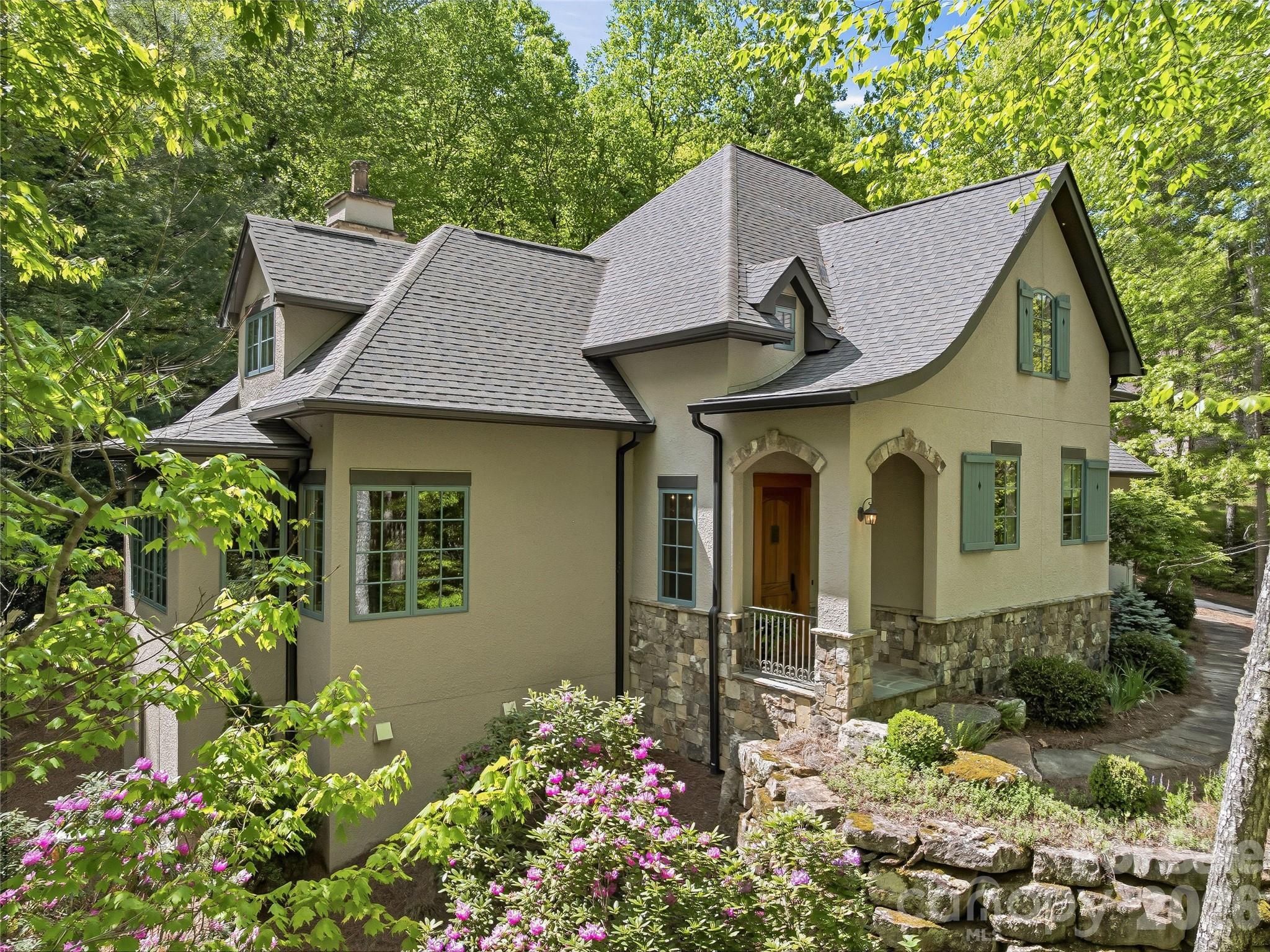 732 Streamside Drive Arden, NC 28704 - Photo 2 of 46 a view of a white house with a flower garden