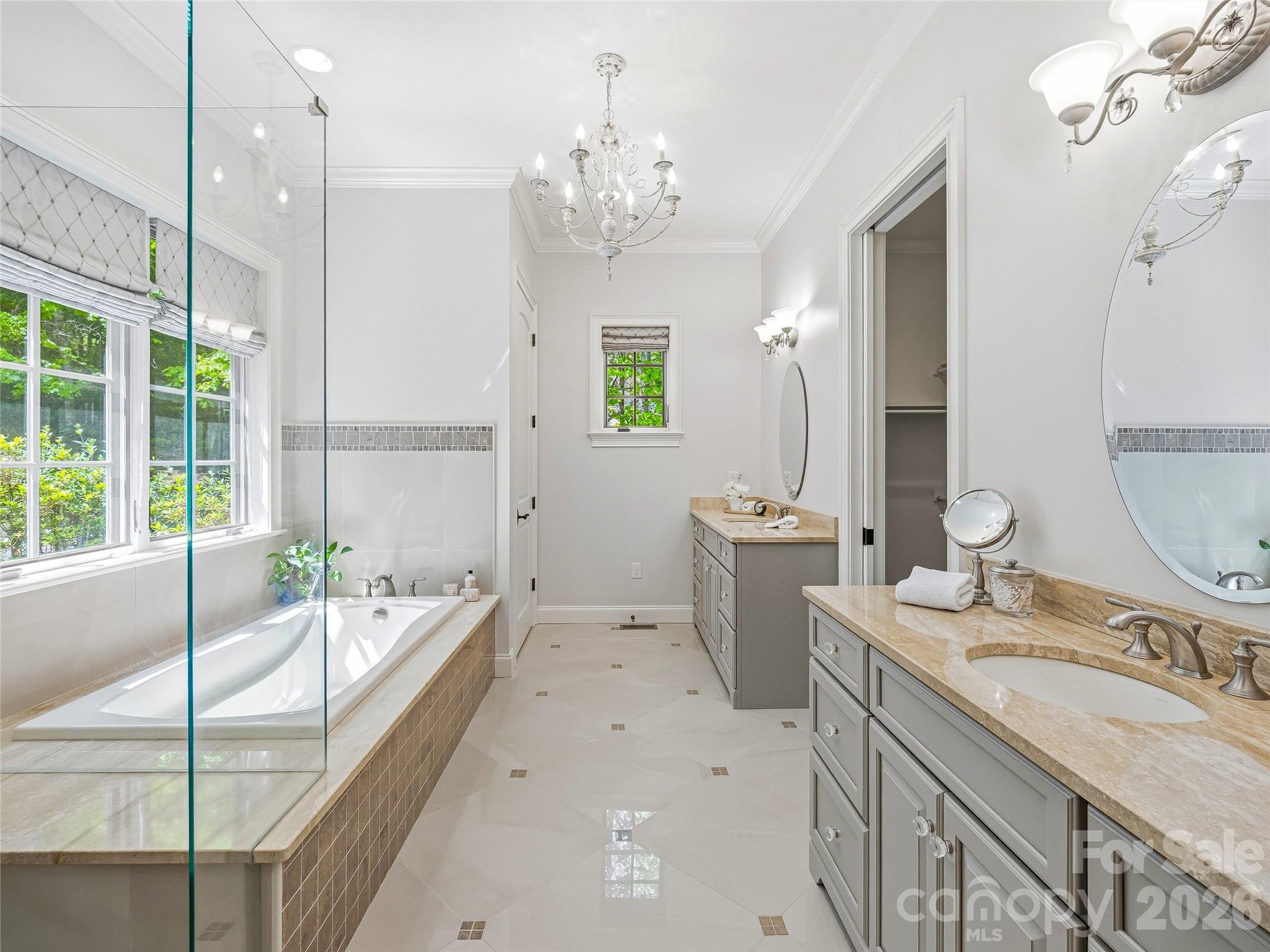732 Streamside Drive Arden, NC 28704 - Photo 25 of 46 a spacious bathroom with a granite countertop sink a large mirror a bathtub and next to a window