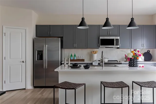 a kitchen with stainless steel appliances a stove a sink and a refrigerator