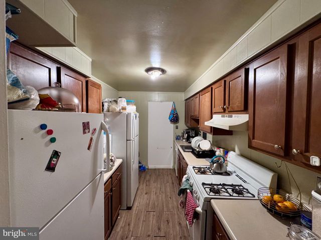 a kitchen with stainless steel appliances granite countertop a refrigerator stove and wooden floors