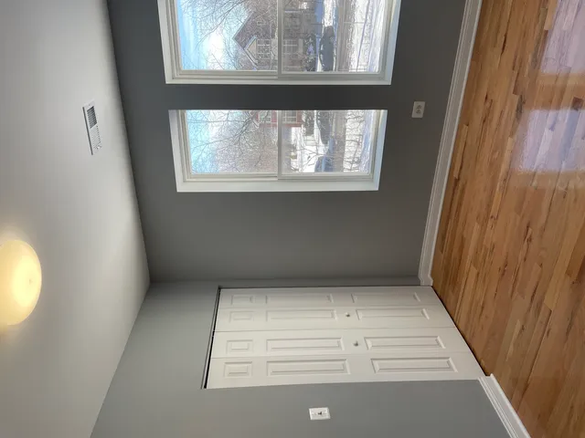 a view of a small space with wooden floor and a window