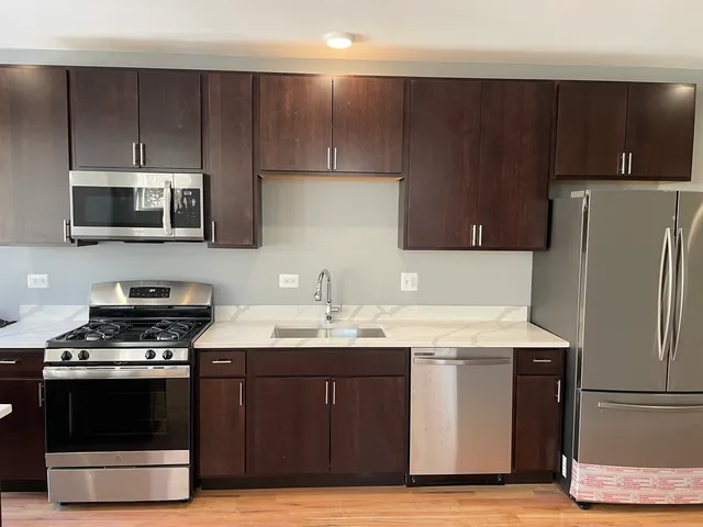 a kitchen with a sink a stove a microwave and refrigerator