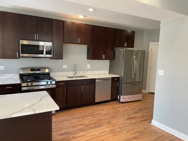 a kitchen with stainless steel appliances a refrigerator stove microwave and sink