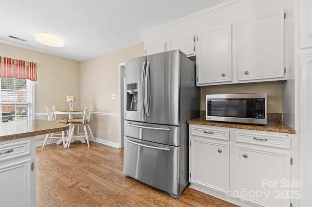 a kitchen with granite countertop white cabinets and stainless steel appliances
