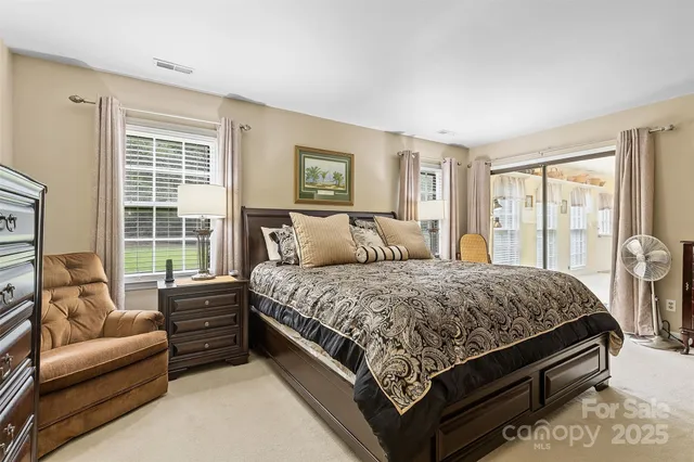 a bedroom with a bed couch and a large window