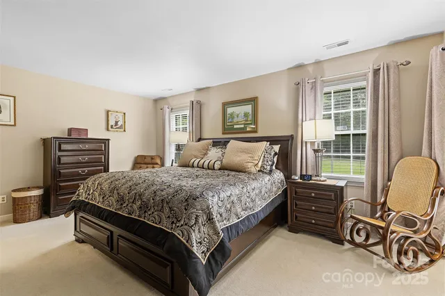 a bed room with a bed window and a chair