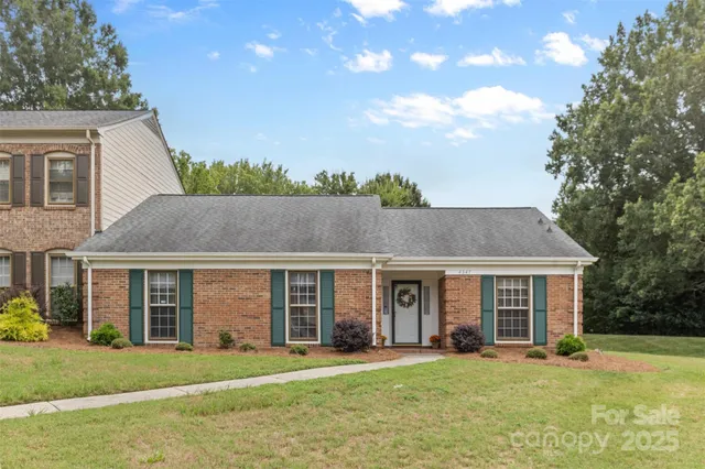 a front view of a house with a garden and trees