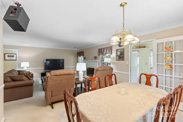 a living room with furniture a chandelier and a flat screen tv