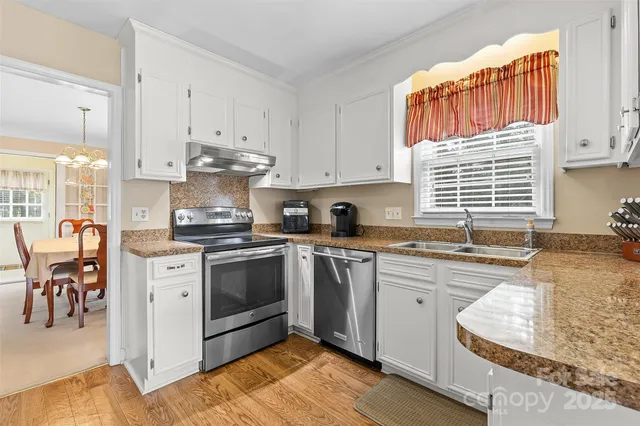 a kitchen with granite countertop white cabinets and white appliances