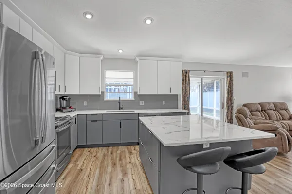 a kitchen with a sink refrigerator and cabinets