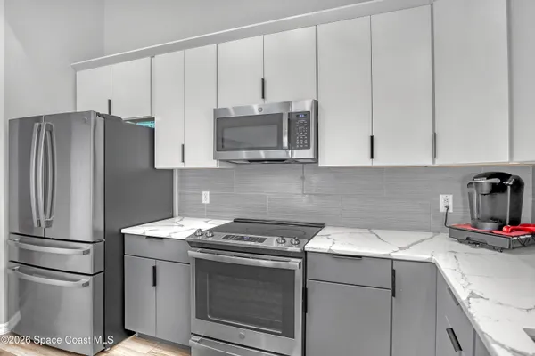a kitchen with appliances a sink and cabinets