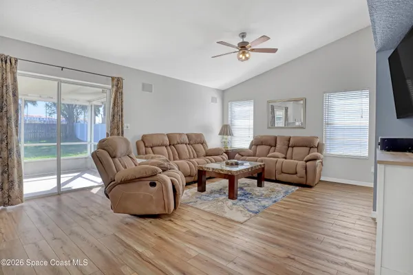 a living room with furniture and a wooden floor