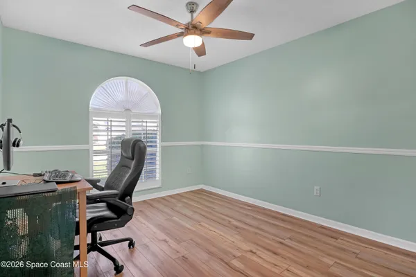 a view of a workspace with furniture and a window