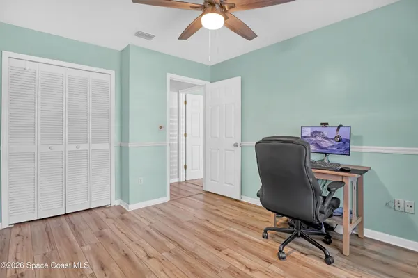 a view of a workspace with furniture and wooden floor