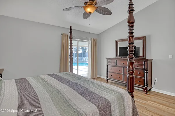 a bedroom with a bed a dresser and a chandelier