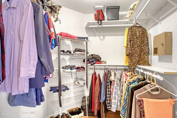a view of walk in closet with clothes