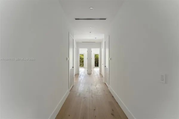 a view of a hallway with wooden floor