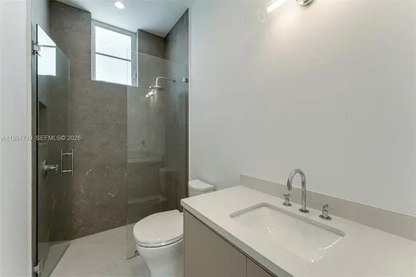 a bathroom with a sink a toilet and shower