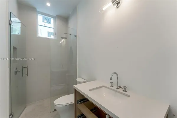 a bathroom with a sink a toilet and shower