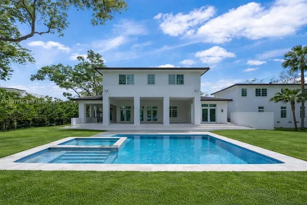 a view of an house with swimming pool and yard