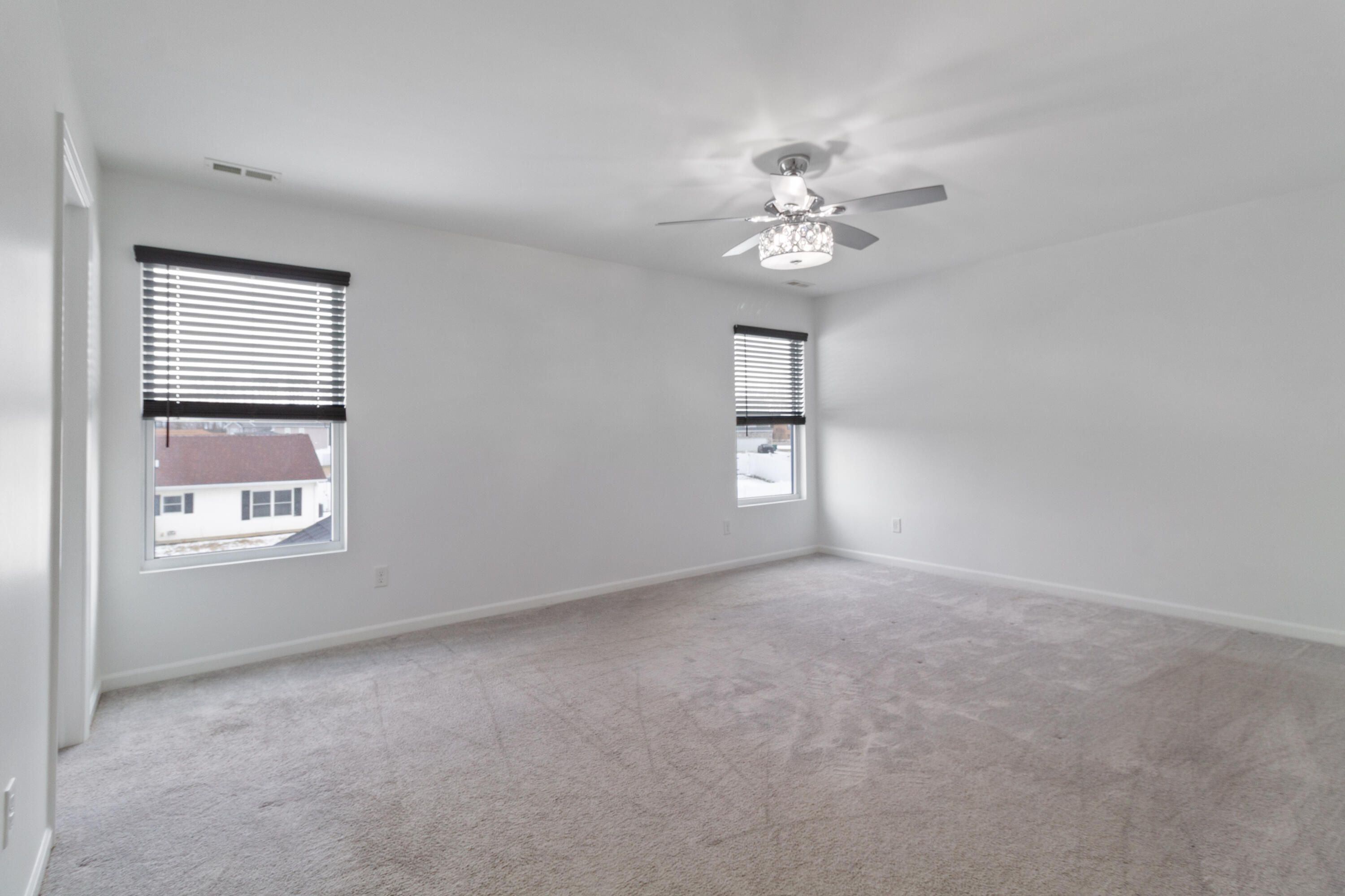 7485 Clark Street Merrillville, IN 46410 - Photo 16 of 26 an empty room with windows and fan