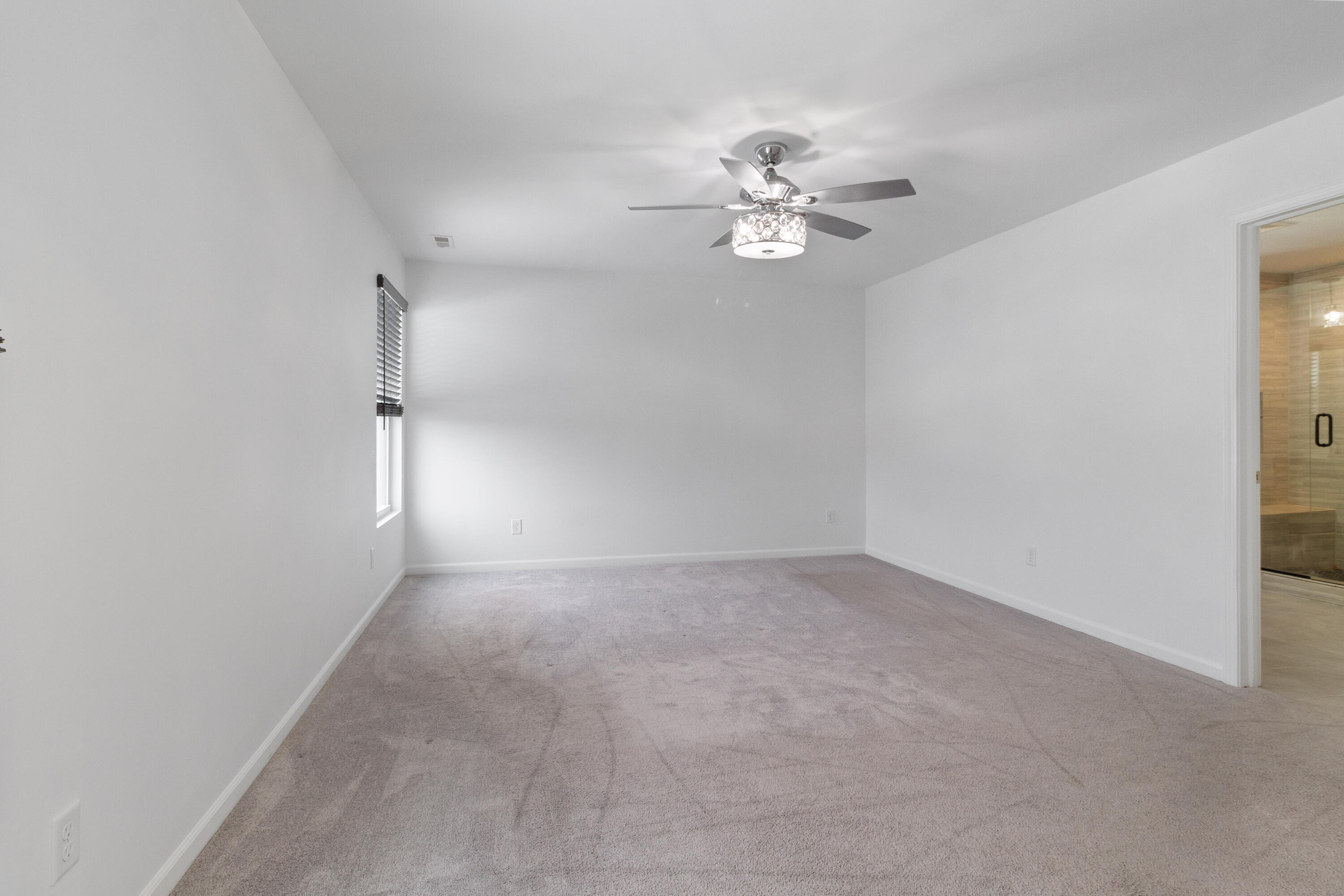 7485 Clark Street Merrillville, IN 46410 - Photo 17 of 26 an empty room with a chandelier fan and windows
