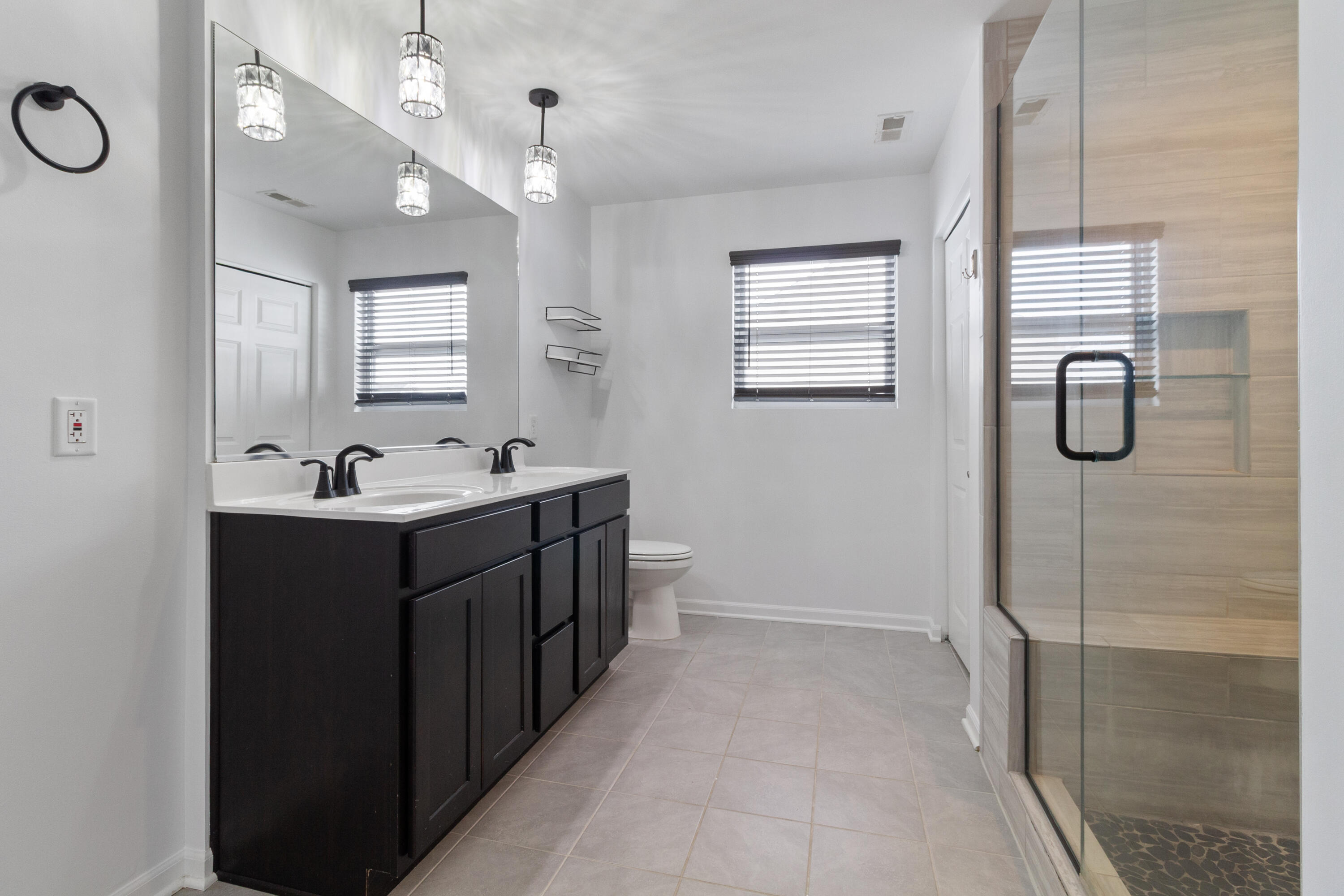 7485 Clark Street Merrillville, IN 46410 - Photo 19 of 26 a bathroom with a double vanity sink a toilet and shower