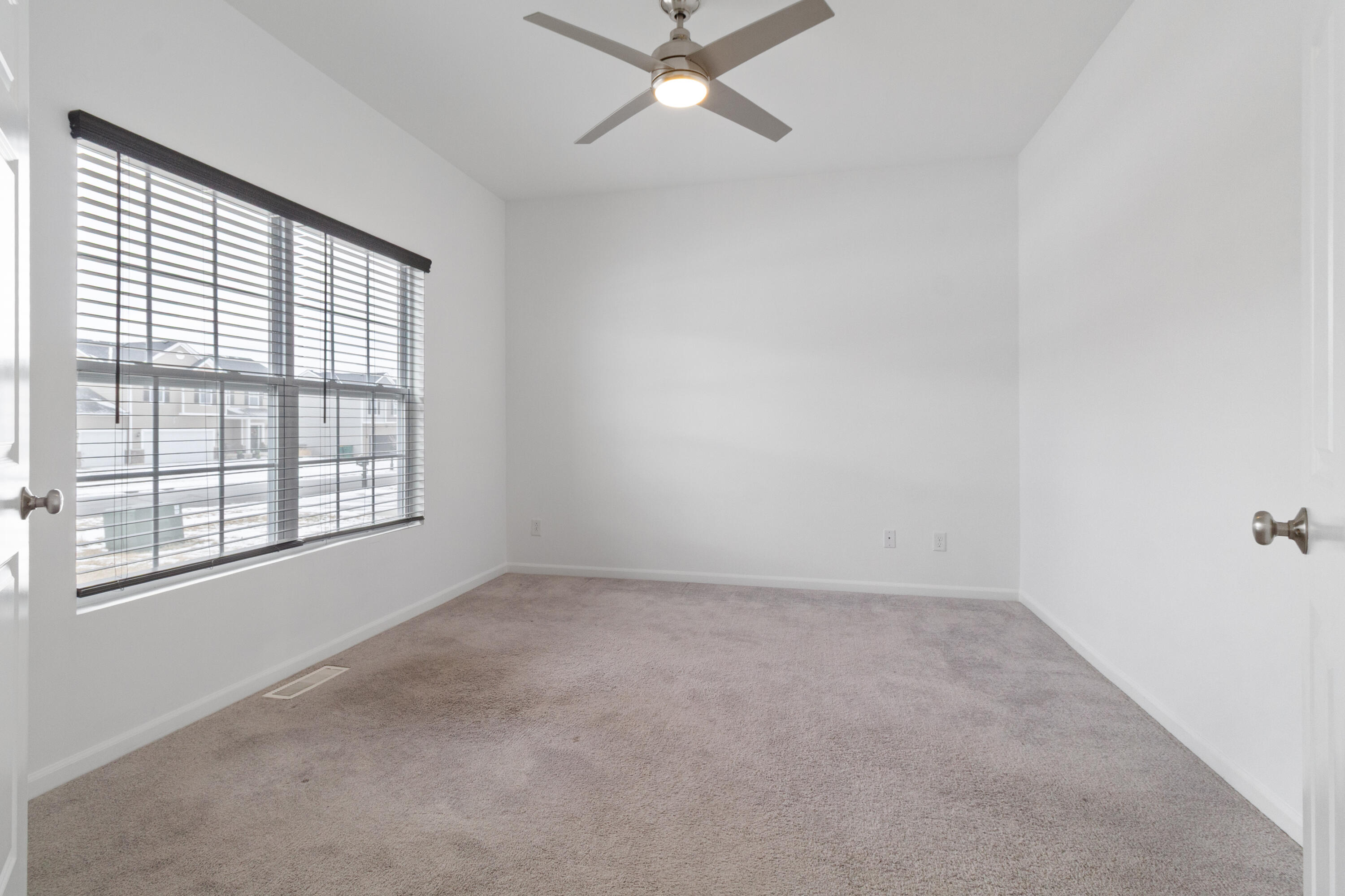 7485 Clark Street Merrillville, IN 46410 - Photo 3 of 26 an empty room with a window and a ceiling fan