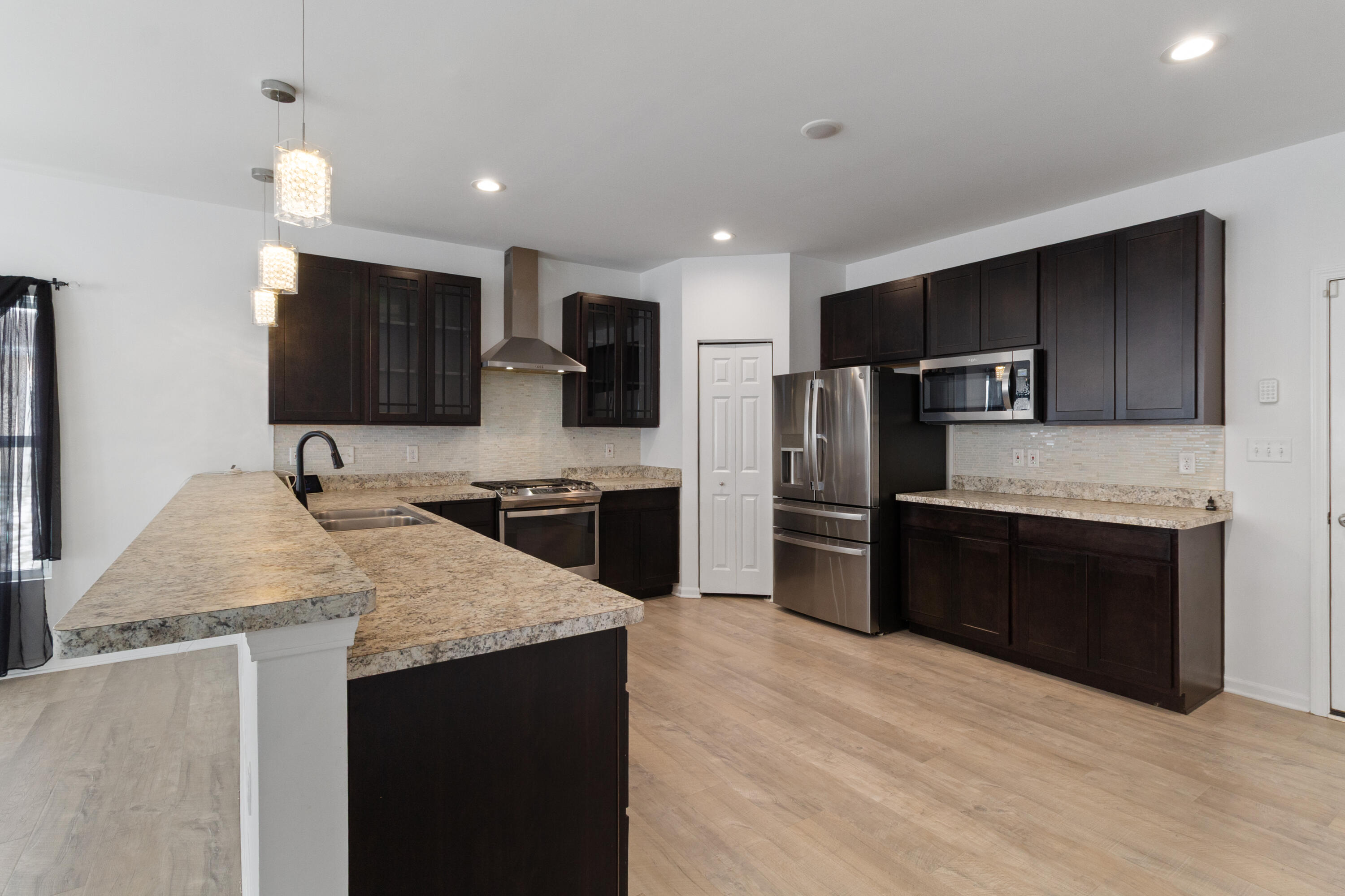 7485 Clark Street Merrillville, IN 46410 - Photo 5 of 26 a kitchen with stainless steel appliances granite countertop a sink refrigerator and microwave