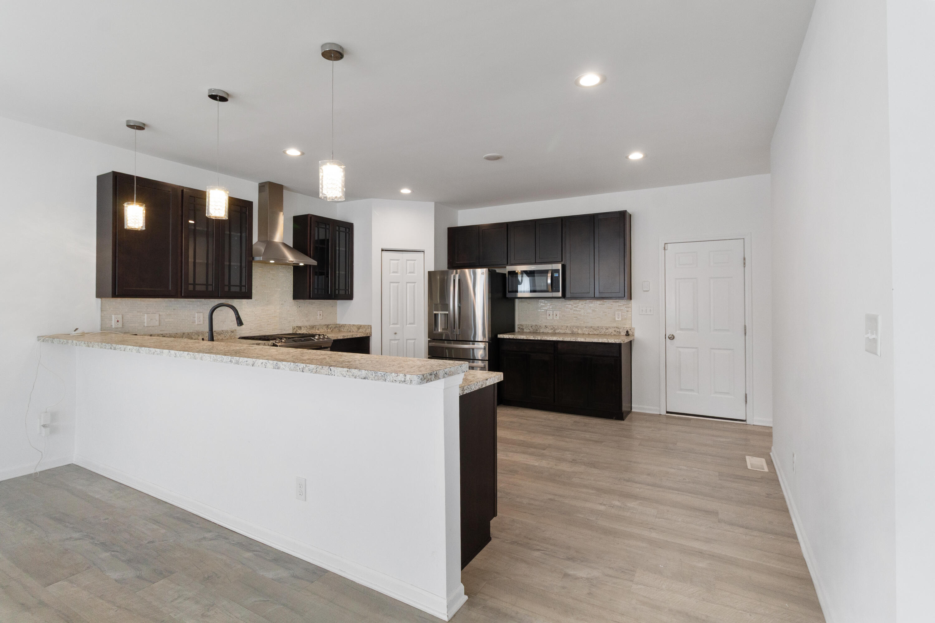7485 Clark Street Merrillville, IN 46410 - Photo 6 of 26 a large kitchen with stainless steel appliances kitchen island granite countertop a large counter top and a stove top oven
