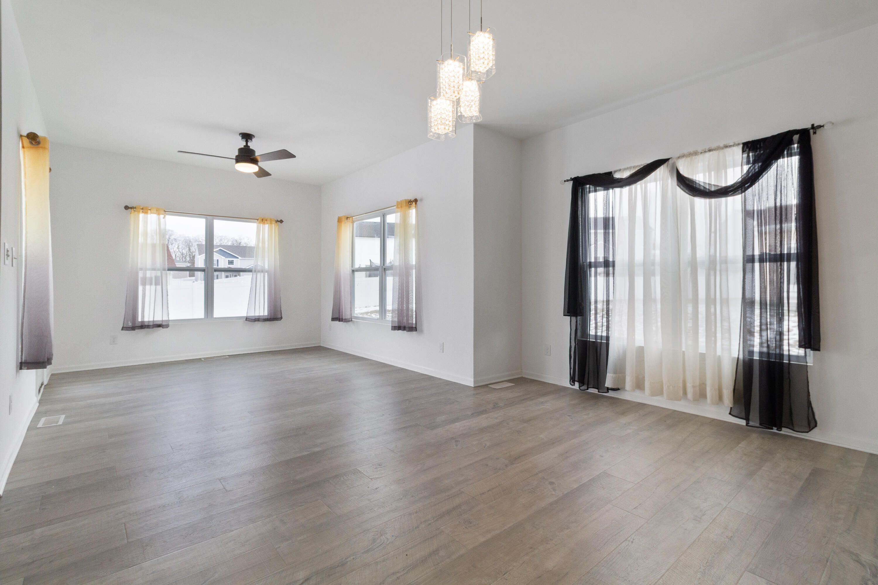 7485 Clark Street Merrillville, IN 46410 - Photo 9 of 26 a view of an empty room with a window and wooden floor