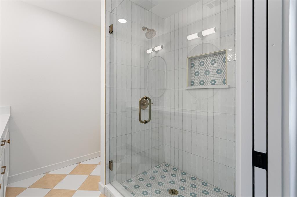 1346 South Reno Road Springtown, TX 76082 - Photo 12 of 24 Glass-enclosed shower featuring a rainfall showerhead, vertical subway tile, and a decorative tiled inset niche with accent lighting