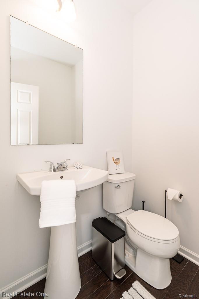 201 Beechview Drive Rochester, MI 48306 - Photo 11 of 49 Powder Room -Pedestal sink with chrome faucet, wall-mounted mirror, and wood-finish flooring