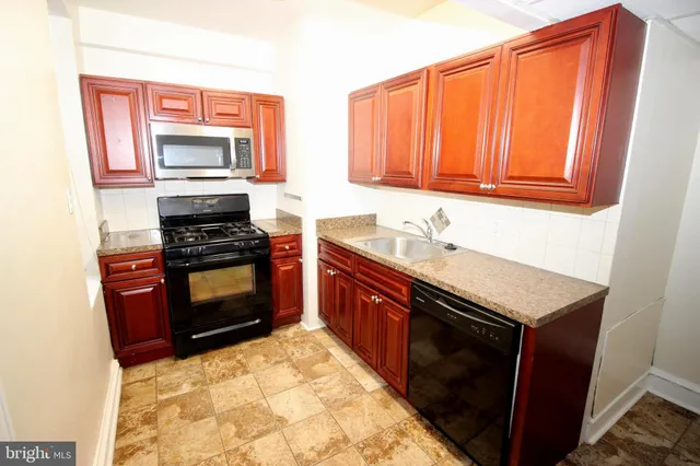 a kitchen with stainless steel appliances a stove sink and microwave