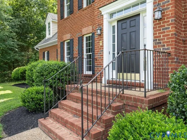 a view of a house with a small yard and wooden floor and fence