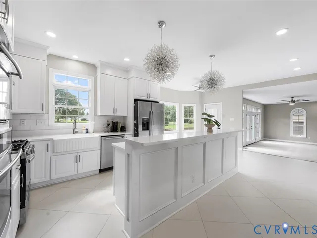 a large kitchen with kitchen island white cabinets and white appliances