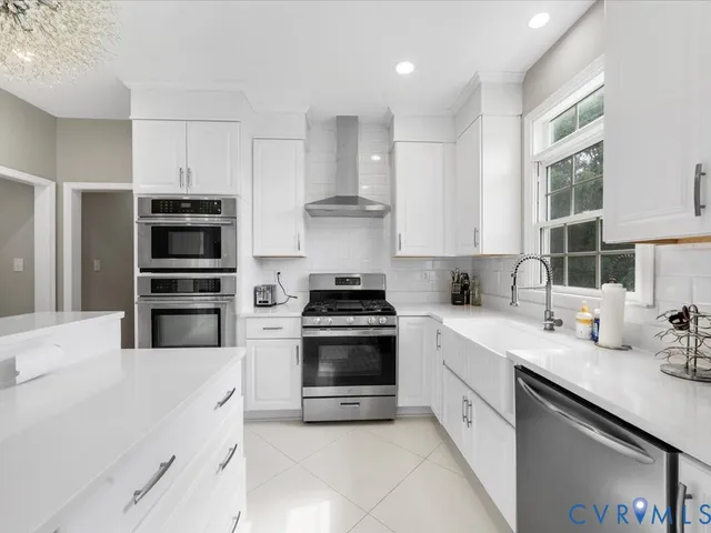 a kitchen with stainless steel appliances granite countertop a stove a sink and a refrigerator