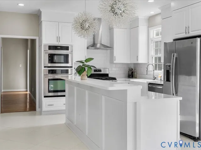 a kitchen with stainless steel appliances a refrigerator sink and stove