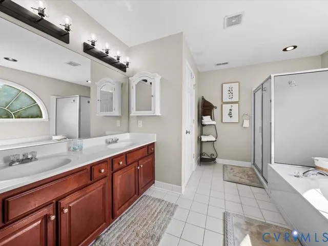 a spacious bathroom with a double vanity sink mirror and a bath tub