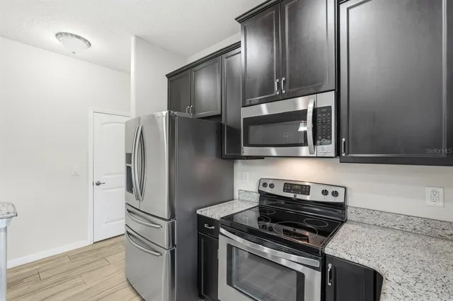 a view of a livingroom with wooden floor a ceiling fan and windows