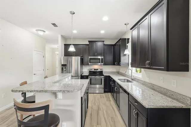 a bathroom with a granite countertop sink a toilet and a mirror
