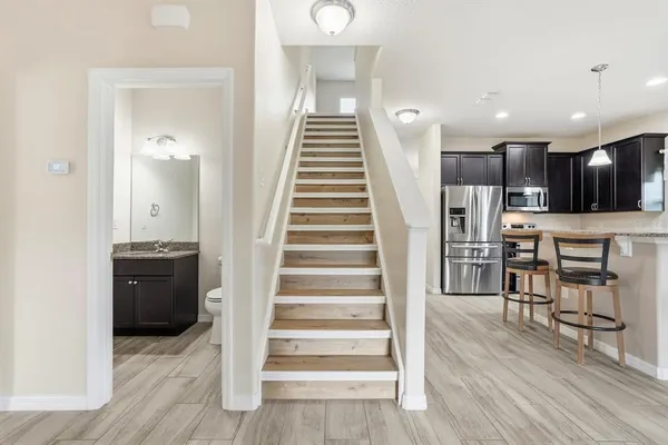 a bathroom with a granite countertop sink a light fixture and a mirror