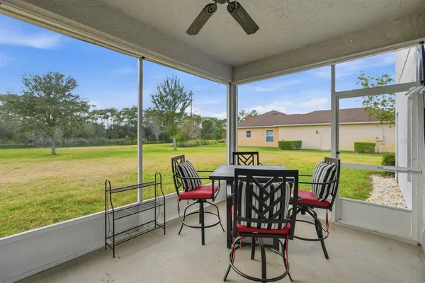 an empty room with wooden floor ceiling fan and windows