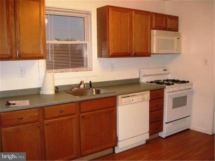 27 Ash Street, Unit B Delran, NJ 08075 - Photo 4 of 9 a kitchen with granite countertop cabinets stainless steel appliances a sink and wooden floor